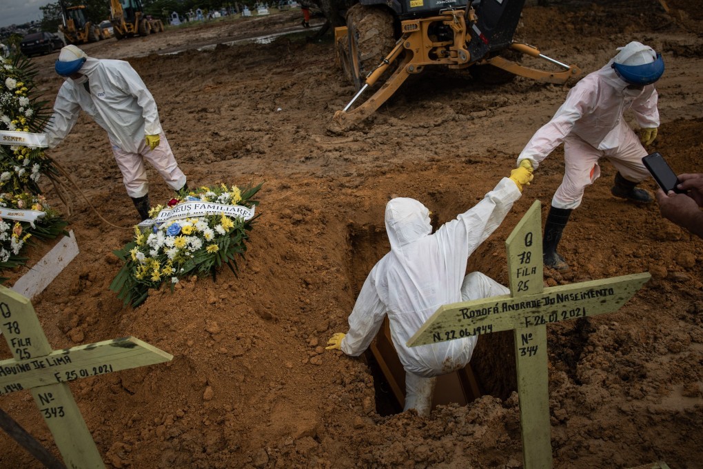 Workers bury a person who died of Covid-19 in the Nossa Senhora Aparecida cemetery in Manaus, Brazil. Photo: EPA