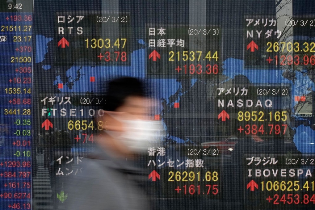 A pedestrian walks past an electric quotation board displaying share prices of the Tokyo Stock Exchange. in Hong Kong, investors suffer a bruising week as the Hang Seng Index retreats by almost 4 per cent. Photo: AFP