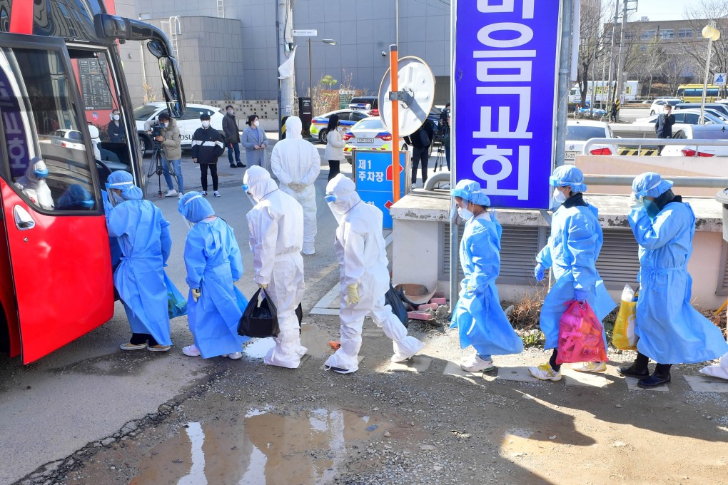 Children in protective clothes who have tested positive for Covid-19 at TCS International School in Gwangju are led onto a bus to travel to medical facilities for treatment. Photo: kjdaily.com for SCMP