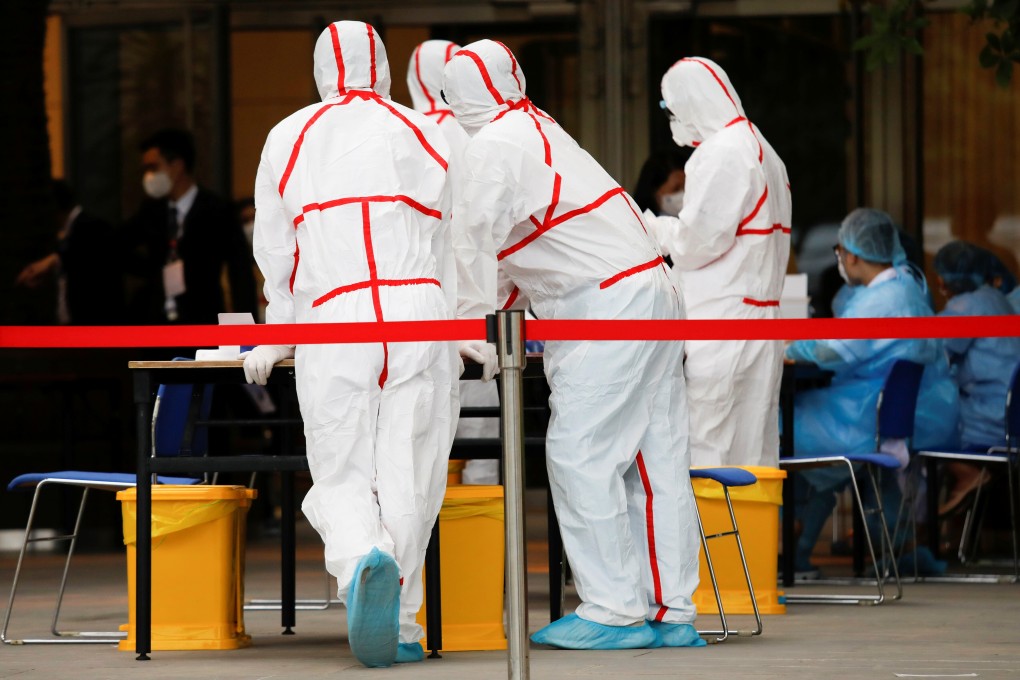 Health workers wearing protective suits are seen at a temporary coronavirus swabbing counter at the National Convention Centre, the venue for the 13th National Congress of the Communist Party of Vietnam. Photo: Reuters