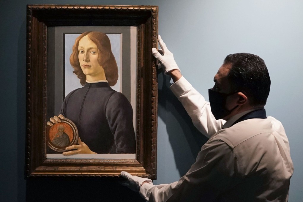 An art handler at Sotheby’s hangs Botticelli’s Young Man Holding a Roundel, which sold in New York for US$92.2 million, smashing the previous auction record for a work by the Italian Renaissance artist. It is considered one of Botticelli’s finest portraits. Photo: AFP