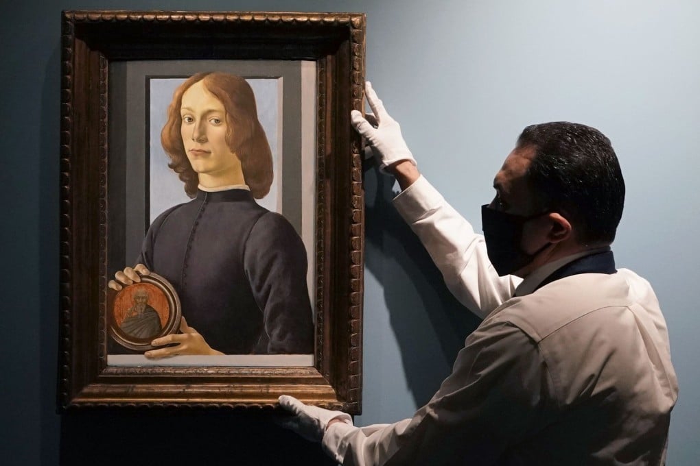 An art handler at Sotheby’s hangs Botticelli’s Young Man Holding a Roundel, which sold in New York for US$92.2 million, smashing the previous auction record for a work by the Italian Renaissance artist. It is considered one of Botticelli’s finest portraits. Photo: AFP