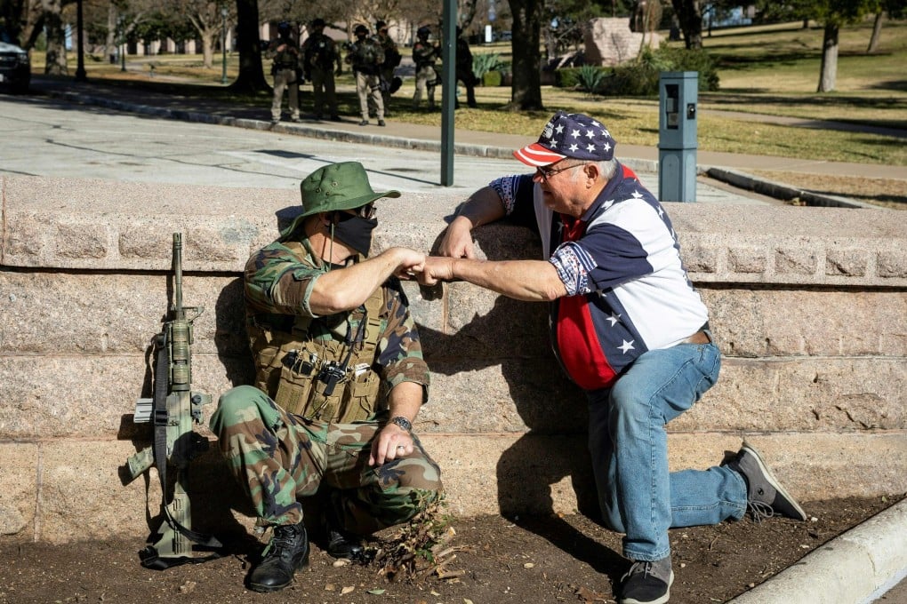 A member of an armed group and a Trump supporter meet during a rally in front of the closed Texas State Capitol in Austin, on January 17, amid unfounded claims of election fraud. Arguably, the first casualty of the Trump years has been trust. Photo: AFP