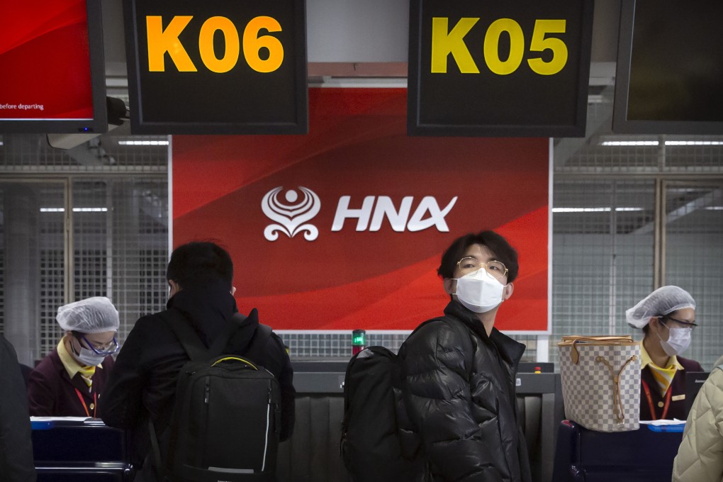 Travellers wearing face masks to protect against the spread of the coronavirus wait in line at the Hainan Airlines check-in counters at Beijing Capital International Airport in Beijing on March 6, 2020. Photo: AP