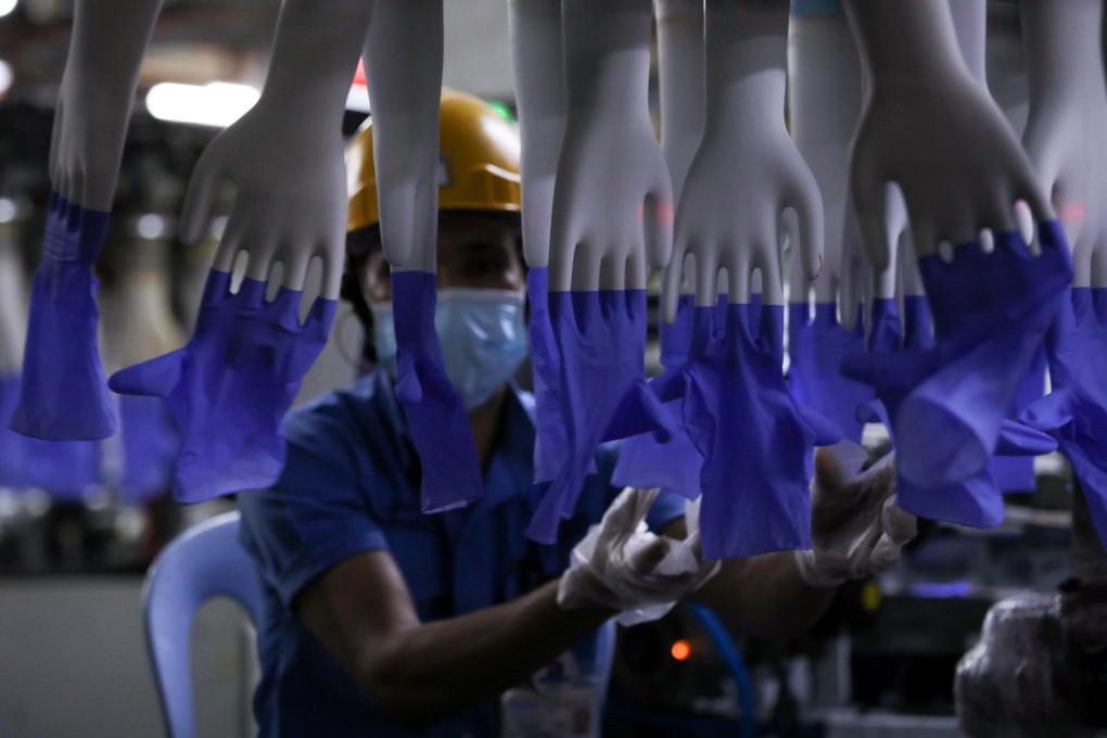 A worker inspects newly-made gloves at Top Glove factory in Shah Alam, Malaysia. File photo: Reuters