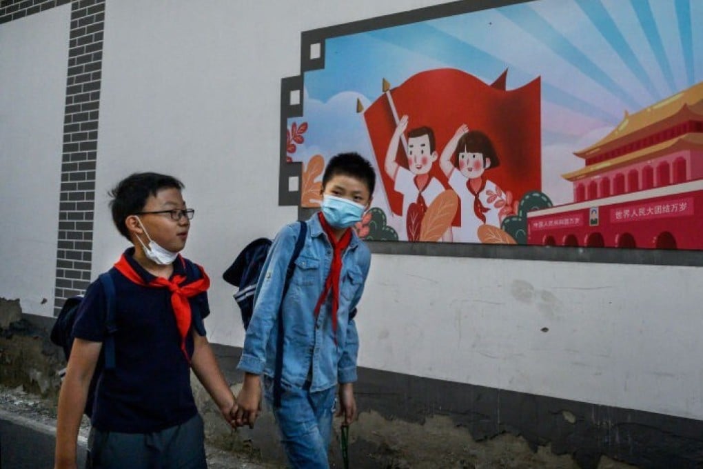 Chinese boys walk home together hand in hand from a local junior school in Beijing, China. Photo: Getty Images