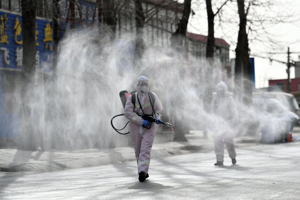 Workers in protective suits spray disinfectant in Gaocheng district, which was declared a high-risk area for Covid-19 in Shijiazhuang, in northern China‘s Hebei province. Photo: AFP