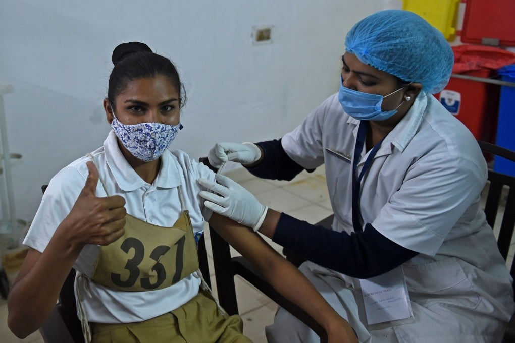 A health worker inoculates a policewoman against Covid-19. Photo: AFP