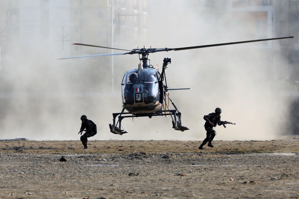 Indian army solders disembark a helicopter while performing an operation demonstration. Photo: Bloomberg