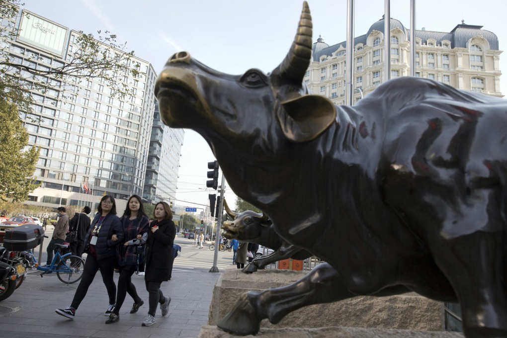 Pedestrians walk past a statue of a bull in Beijing. Alibaba recouped earlier slump to help the Hang Seng Index to a third day of gains on February 3, 2021. Photo: AP