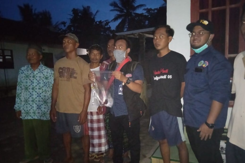 Some of the villagers from Astomulyo, with the one in the centre holding a fragment of the meteorite in a plastic bag. Photo: ITERA Lampung
