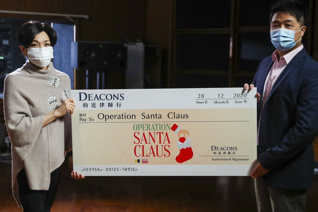 SCMP Charities Ltd project director Lawrence Wong (right) receives a cheque from DEACONS official Lilian Chiang in Kowloon Tong. Photo: Edmond So