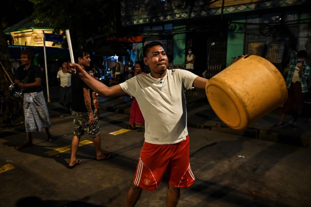 A man hits a plastic container to make noise after calls for protest went out on social media in Yangon on Wednesday. Photo: AFP