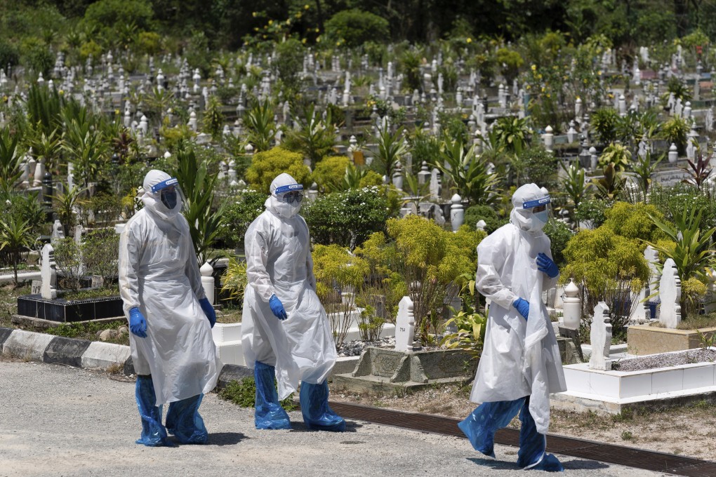 Workers wearing personal protective equipment leave after burying a victim of the coronavirus disease at a Muslim cemetery in Gombak, on the outskirts of Kuala Lumpur, Malaysia. Photo: AP