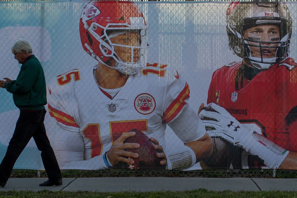 A pedestrian walks past a banner with the portraits of Super Bowl LV quarterback Patrick Mahomes (left) and Tom Brady, ahead of the NFL Super Bowl LV in Tampa, Florida. Photo: EPA