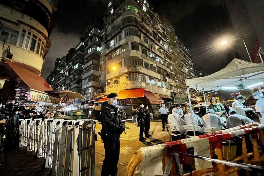 Police officers stand guard while health workers take swabs from residents of the 17 buildings in Sham Shui Po that were locked down on February 2 to carry out compulsory coronavirus tests. Photo: TPG via ZUMA Press / dpa