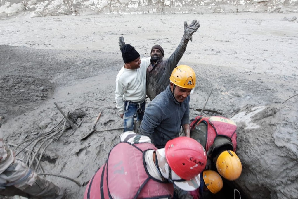 A hydropower plant worker raises his arms in joy after he was pulled out from beneath the ground during rescue operations after a portion of Nanda Devi glacier broke off in the Tapovan area. Photo: AP