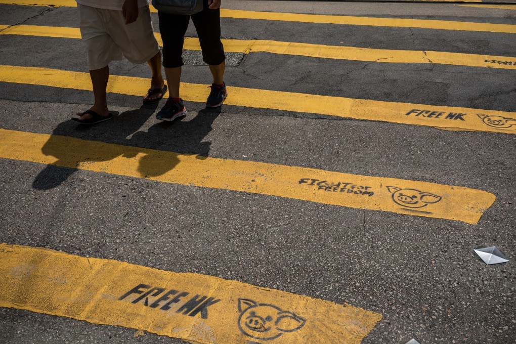 Pedestrians walk past graffiti on a pedestrian crossing reading “Free HK” and “Fight For Freedom” in Causeway Bay, Hong Kong, on October 2, 2019. Photo: Bloomberg