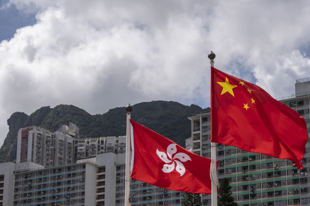 The Hong Kong and Chinese flags fly against a backdrop of highrise buildings and Lion’s Rock mountain, in Wong Tai Sin district of Hong Kong. Photo: Sun Yeung