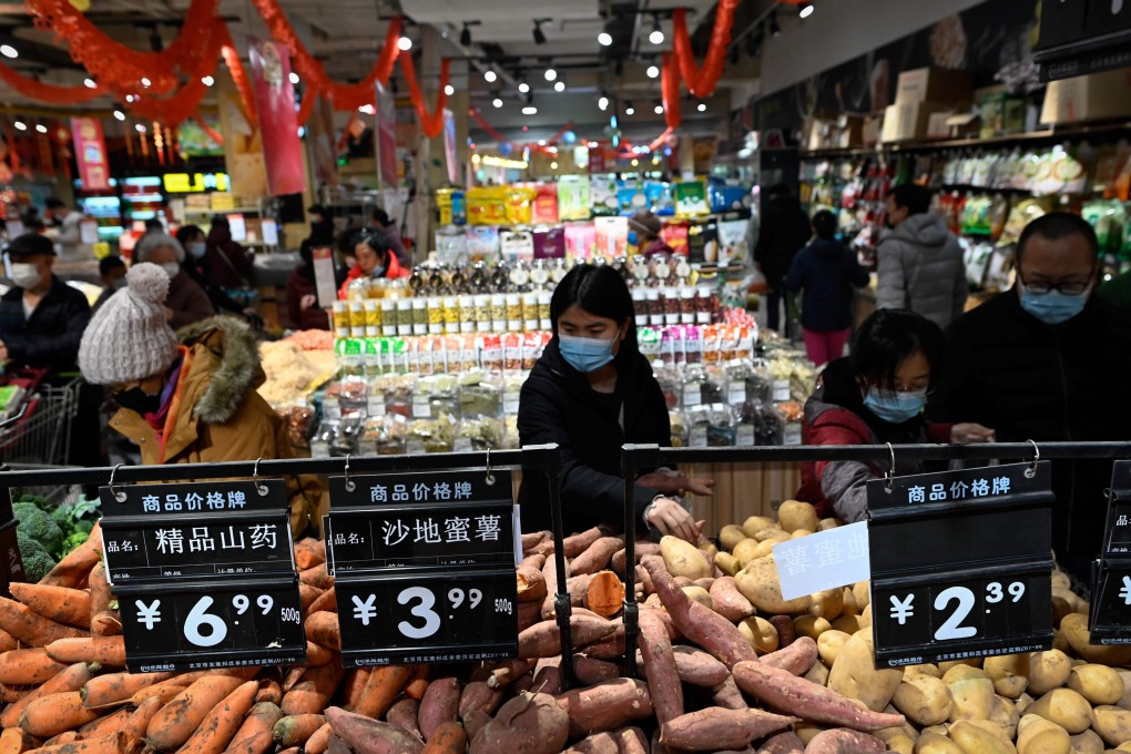 People select vegetables at a supermarket in Beijing on February 10. There is little chance of China, the growth engine of the global economy, exporting inflation any time soon. Photo: AFP