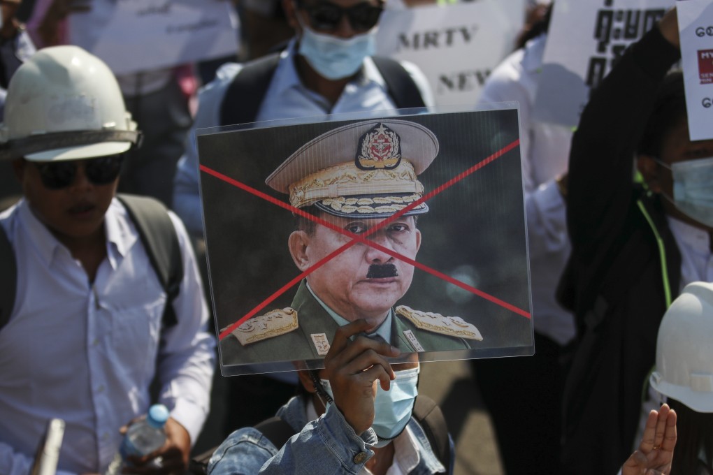 A protester holds up a defaced portrait of junta chief General Min Aung Hlaing at a rally against the military coup in Naypyidaw on Thursday. Photo: EPA