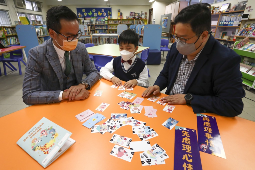 (Left to right) School principal Kwok Chiu-kwan, student Colin Choi and his father, Michael Choi, use flash cards developed by Just Feel. Photo: Jonathan Wong