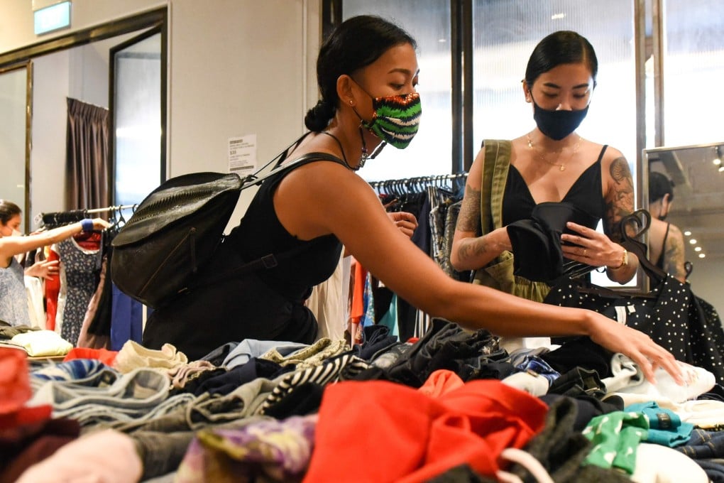 Nadia Kishlan (left) browsing through secondhand clothes at a pop-up swap event organised by a group of volunteers in Singapore. Photo: AFP