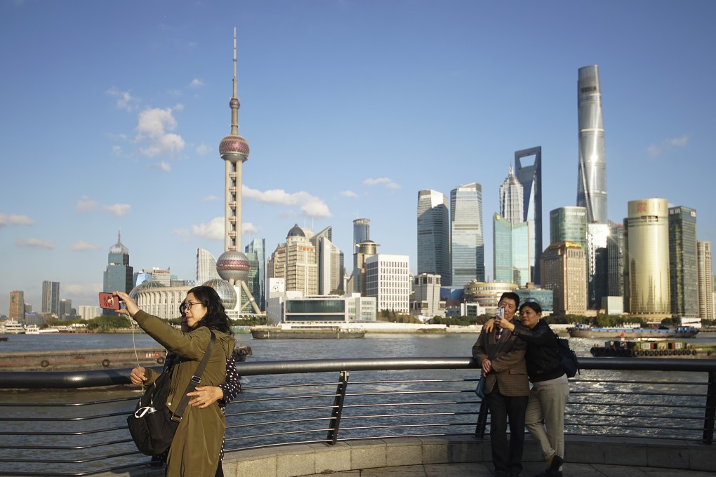 People take selfies of the Pudong skyline as they stand on the Bund in Shanghai in November last year. China’s successes have come at a cost that outsiders cannot easily see. Photo: AP