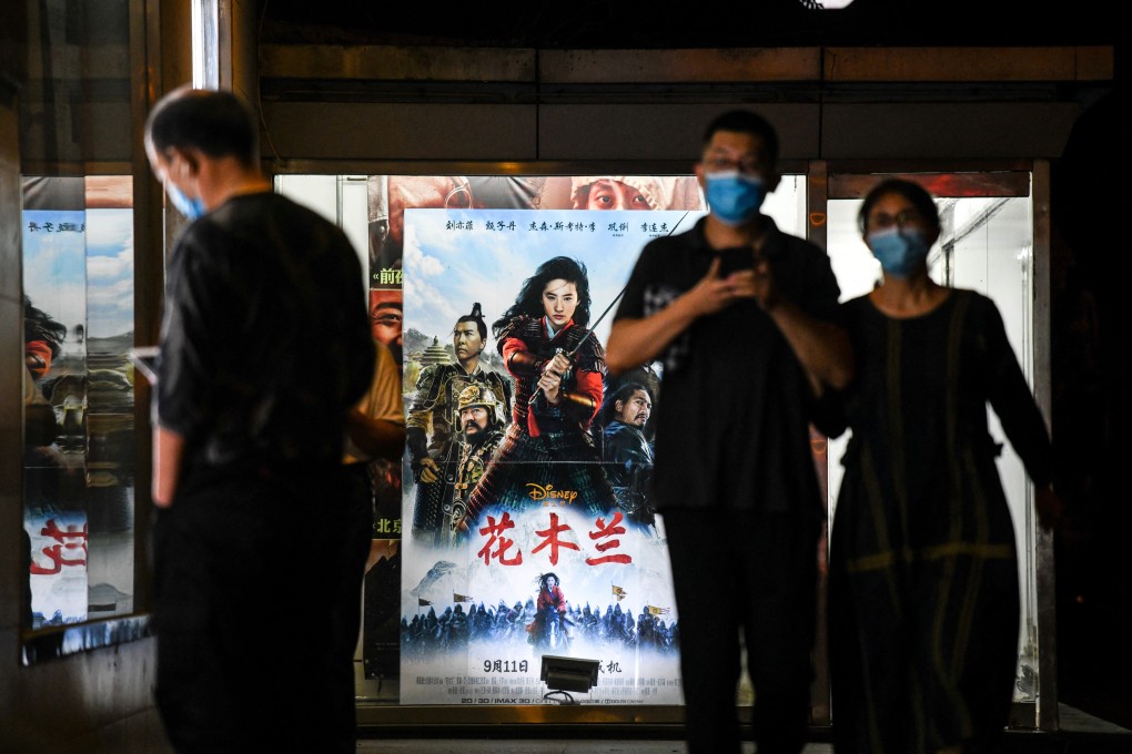 People walk past a poster of the Disney movie Mulan outside a cinema in Beijing in September. Photo: AFP