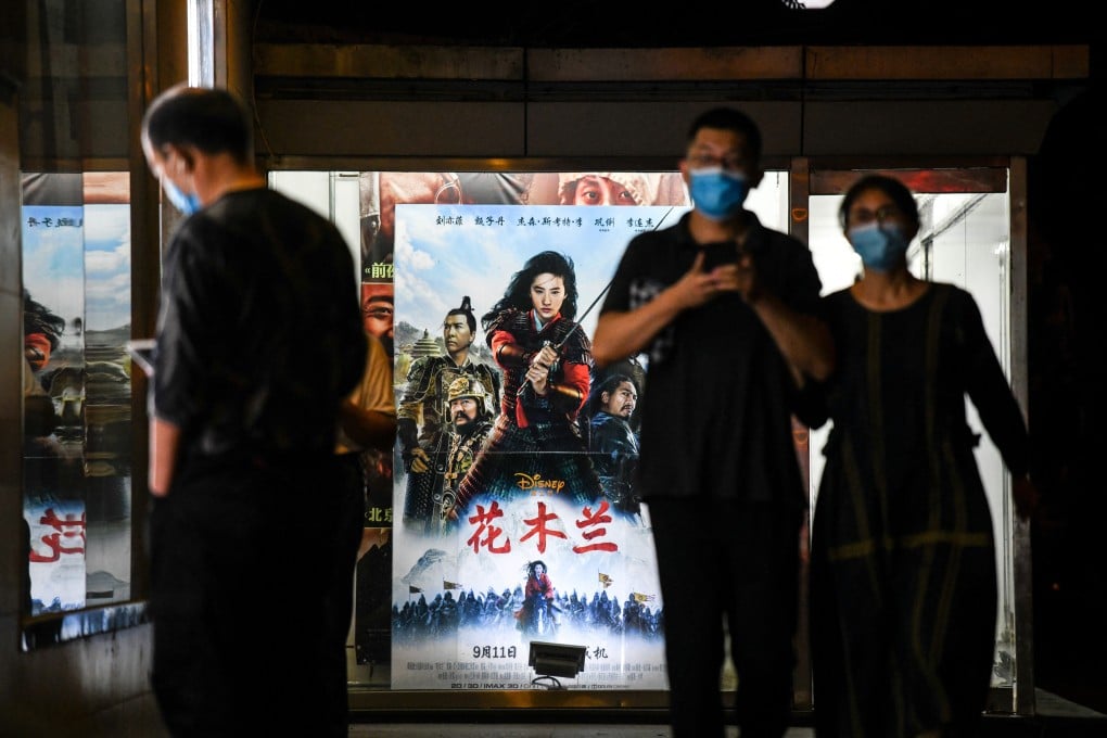 People walk past a poster of the Disney movie Mulan outside a cinema in Beijing in September. Photo: AFP