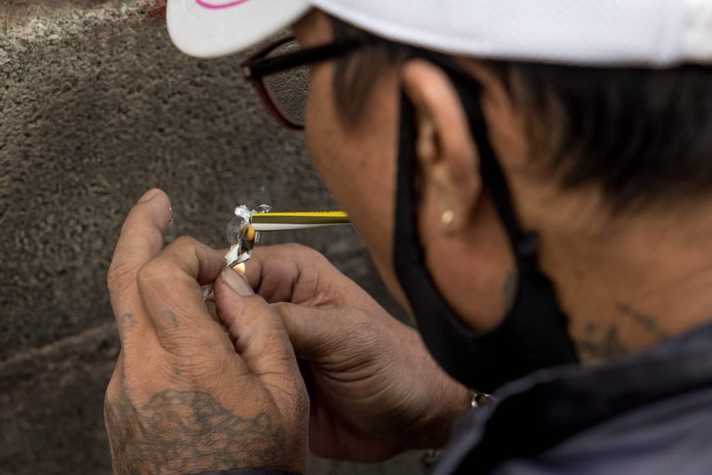 A motorbike taxi driver smokes a methamphetamine pill in Bangkok, which has seen a surge in cut-price ‘yaba’ tablets in the local market. Photo: AFP