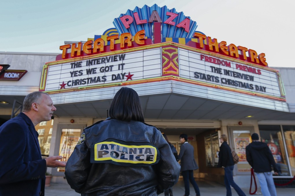 An off-duty police officer hired by the cinema stands watch as people arrive to watch the controversial movie The Interview at the Plaza Theatre in Atlanta, Georgia, in December 2014. The Sony Pictures comedy was the subject of threats by North Korea after a hacking attack. Photo: EPA