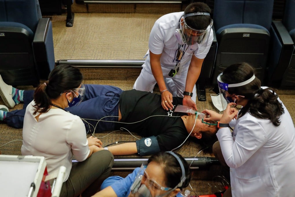 Health workers attend to a man faking an adverse reaction to a vaccine during a practice drill at a hospital in Metro Manila on Thursday. The Philippines has struggled to make a start on its inoculation programme. Photo: EPA-EFE