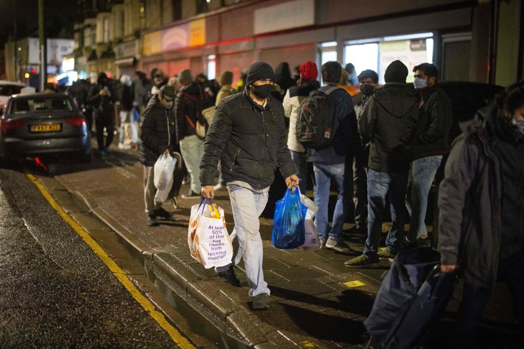 An international student leaves after collecting food packages from the Newham Community Project food bank in east London on February 16. Photo: AFP