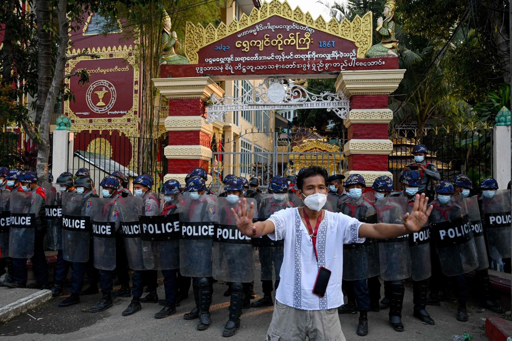 A man gestures as police guard the entrance a Buddhist monastery where pro-military supporters took shelter after clashes with local residents following a demonstration in Yangon on Thursday. Photo: AFP