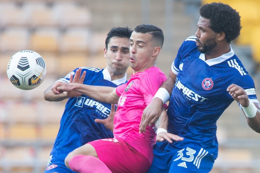 Resources Capital’s Felipe Sa (centre) tries to escape the attentions of Eastern defenders Alexander Jojo (left) and Eduardo Praes in the Sapling Cup. Photo: HKFA