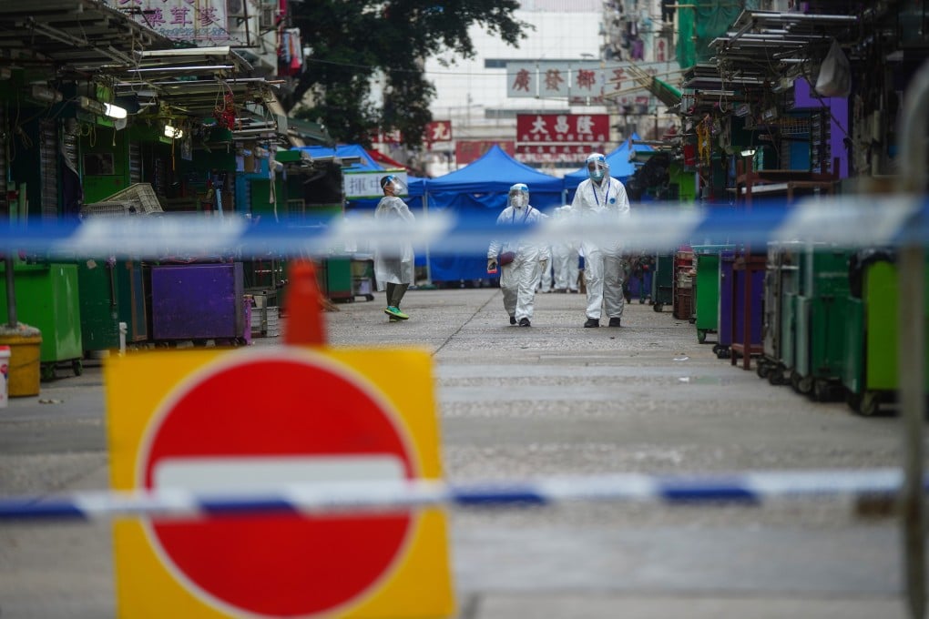 Government officers stand guard at the perimeter of a Covid-19 lock down zone in Yau Ma Tei. Photo: Sam Tsang