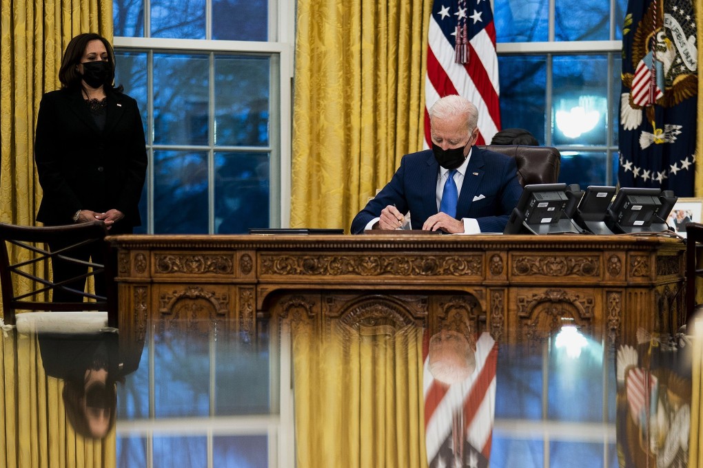 US President Joe Biden signs several executive orders directing immigration actions for his administration as Vice-President Kamala Harris looks on. Photo: TNS