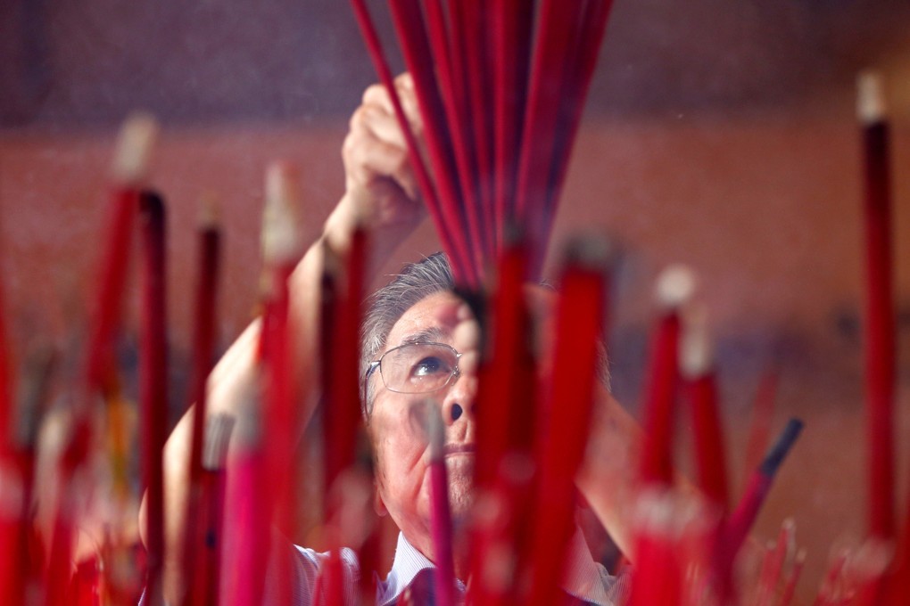 A man prays during Lunar New Year celebrations at a temple in Jakarta, Indonesia. Photo: Reuters
