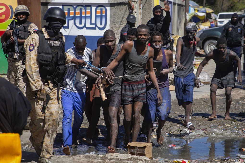 Recaptured inmates are led by police outside the Croix-des-Bouquets Civil Prison after a mass breakout. Photo: AP