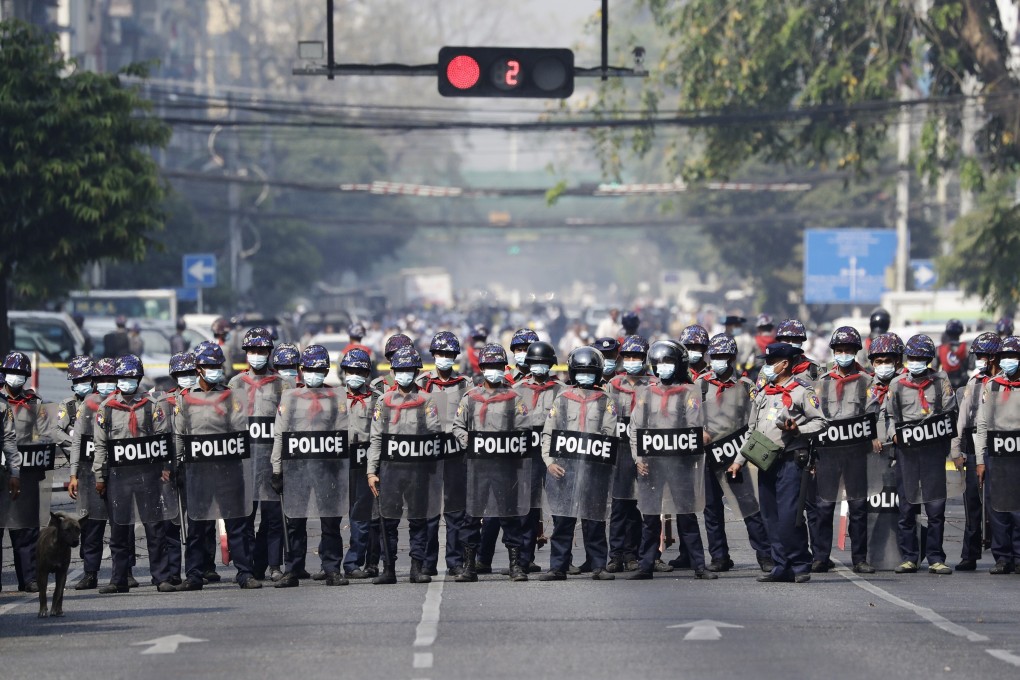 Riot police stand guard on a road in Yangon during a protest on Sunday against Myanmar’s military coup. Photo: EPA