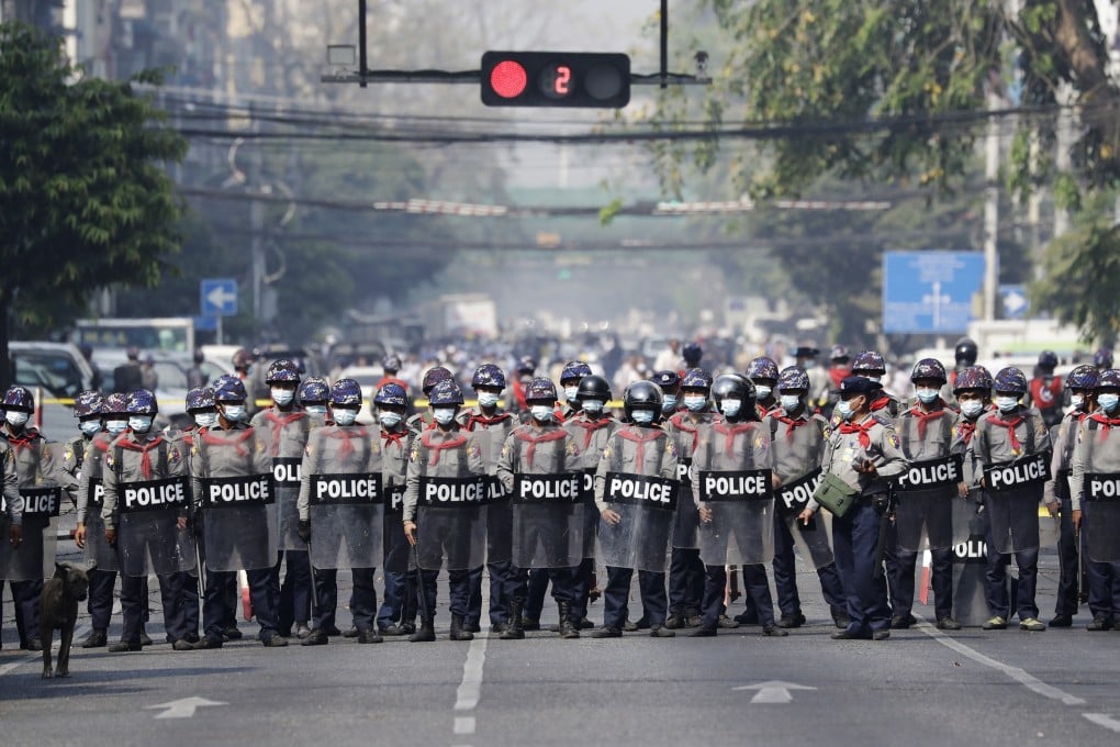Riot police stand guard on a road in Yangon during a protest on Sunday against Myanmar’s military coup. Photo: EPA