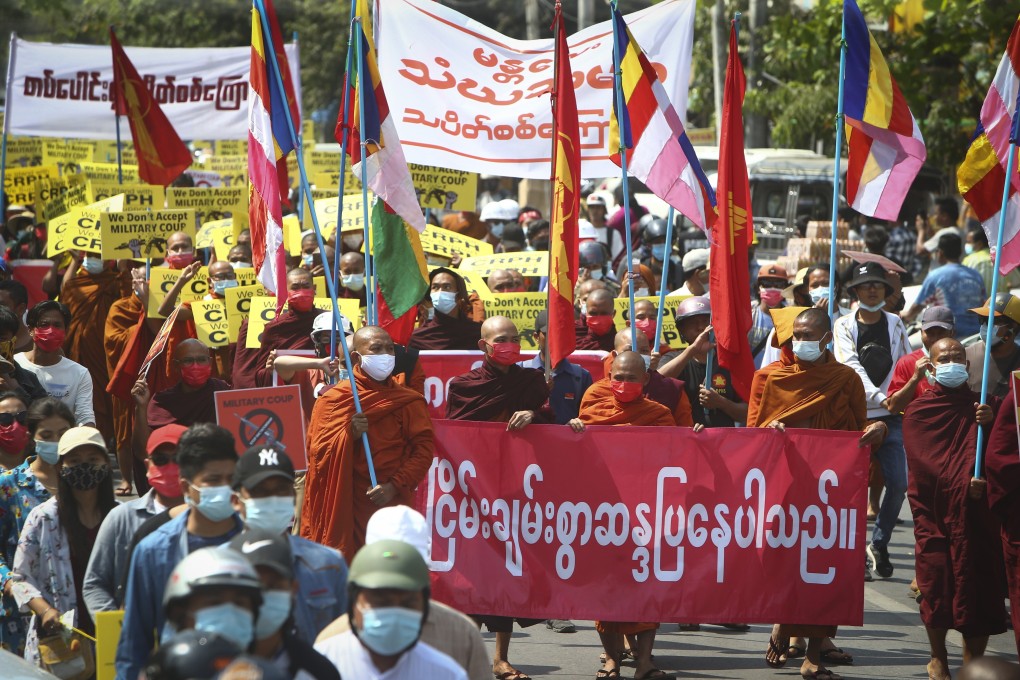 Buddhist monks holding banners and signs lead an anti-coup protest march in Mandalay, Myanmar, on Monday. Photo: AP