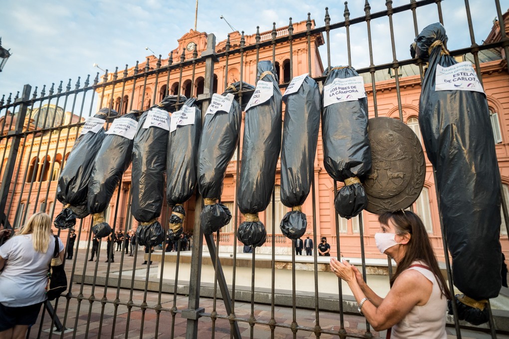 Mock body bags, symbolising those who died without Covid-19 vaccination, hang on the gates of Buenos Aires’ Government House. Photo: DPA