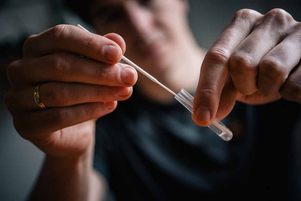 A man holds a swab and tube used for nasal testing. Some Japanese employees in China have called coronavirus tests using anal swabs an action that would humiliate people. Photo: DPA