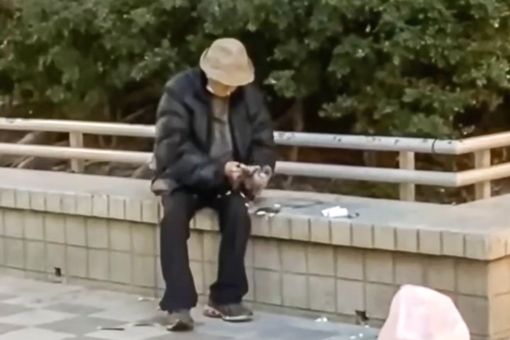 A still from a viral video showing an elderly man plucking a pigeon outside a housing estate in Wong Tai Sin on Tuesday. Photo: Handout