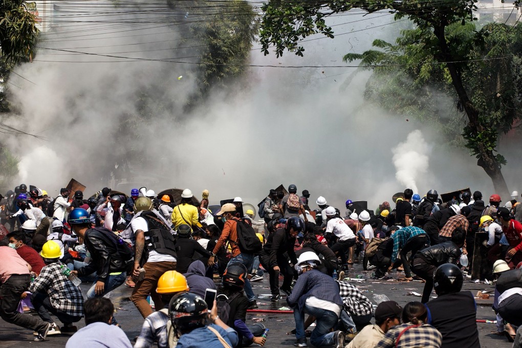 Protesters scatter after police fired tear gas during a demonstration against the military coup in Mandalay on March 3. Photo: AFP