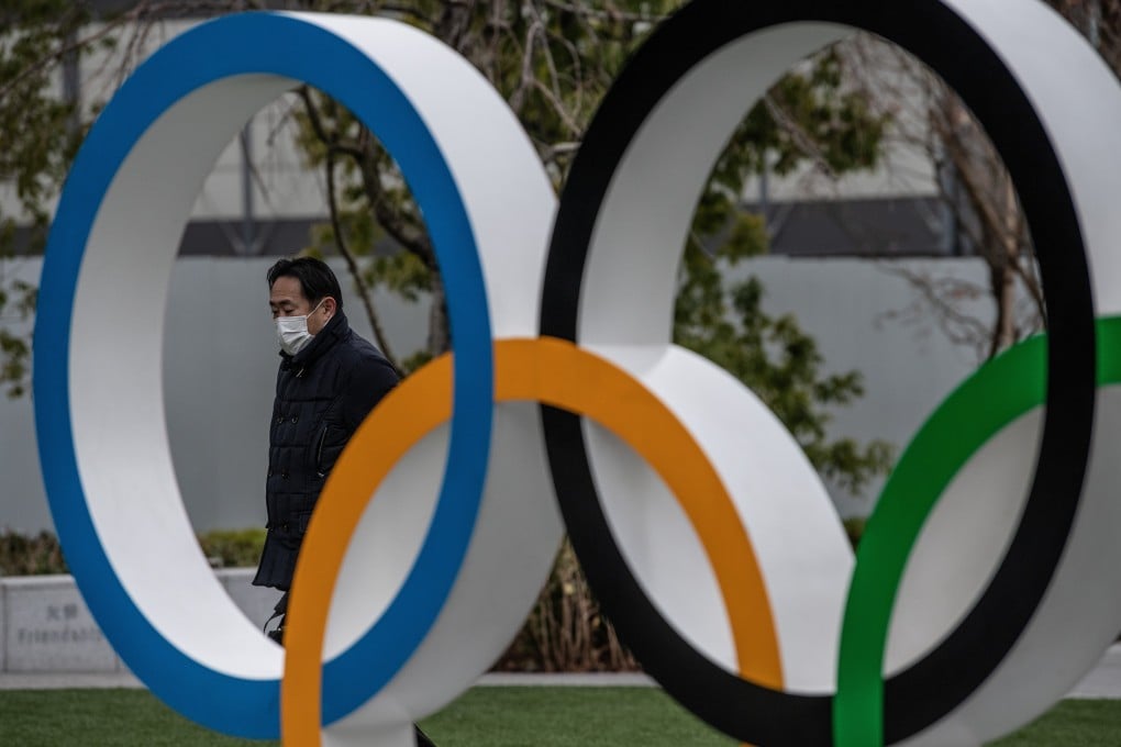 A man wearing a face mask walks past the Olympic Rings in Tokyo, Japan in January. Photo: Carl Court/Getty Images