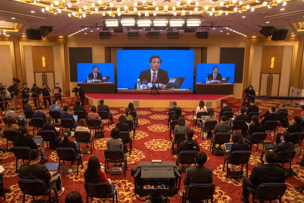 Zhang Yesui, the spokesperson for the fourth session of the 13th National People's Congress (NPC), is seen on screens as he speaks during an online press conference in Beijing, March 4, 2021. Photo: EPA-EFE