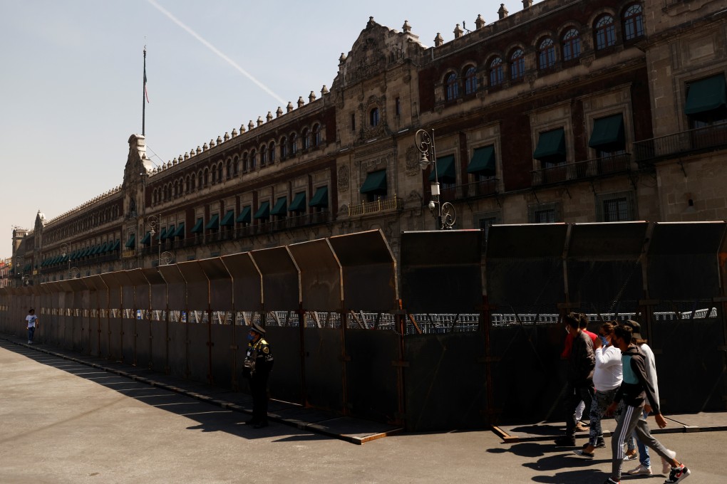 People walk past fences placed outside the National Palace in Mexico City. Photo: Reuters